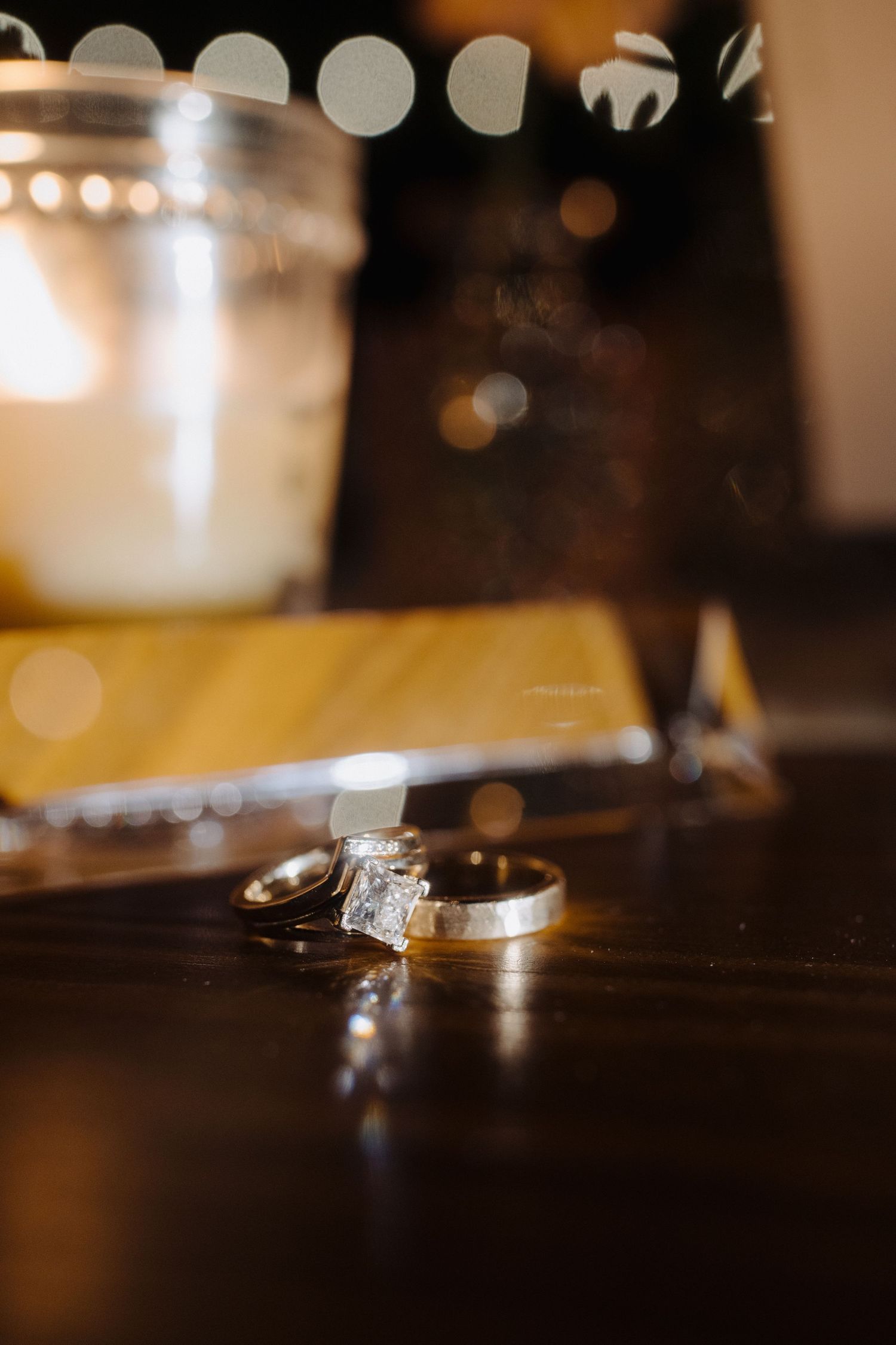 Close-up of wedding rings with soft bokeh lighting in background.