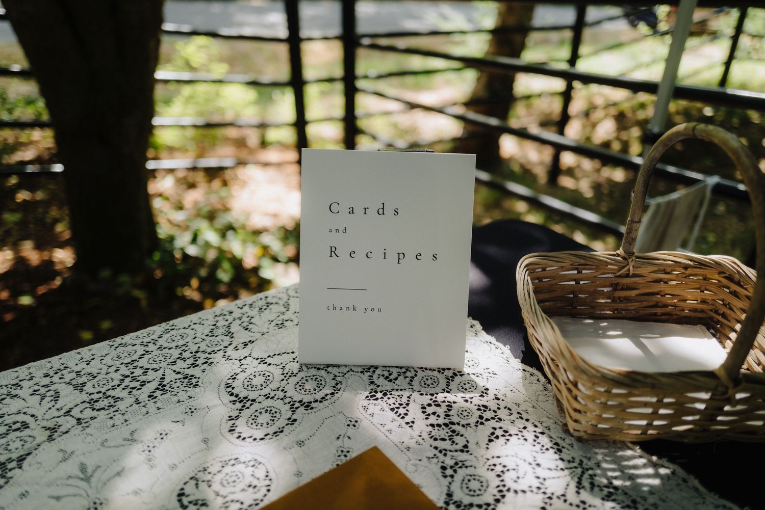 Elegant lace tablecloths with recipe cards and place settings at a wedding reception.