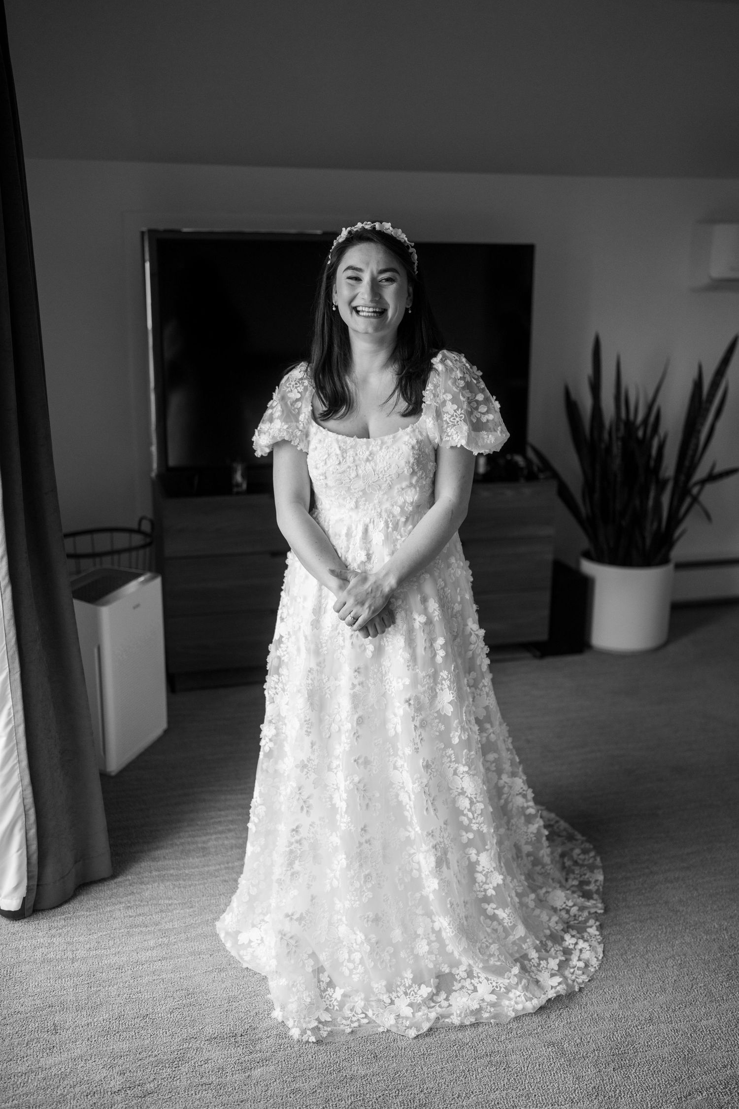 Bride in a white lace wedding dress with puff sleeves twirls and poses in an indoor setting.