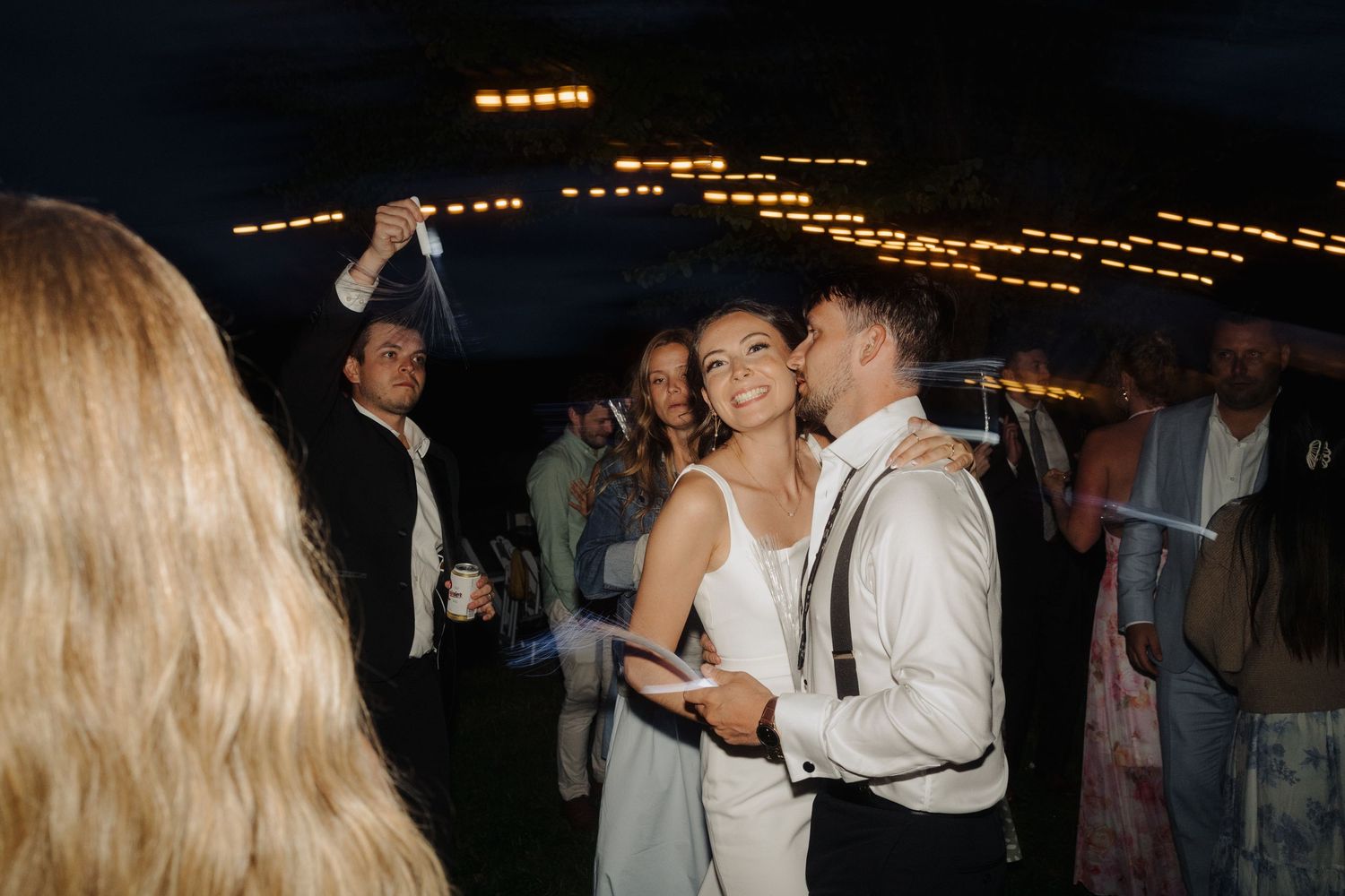 A nighttime wedding celebration with string lights creating a warm ambiance.