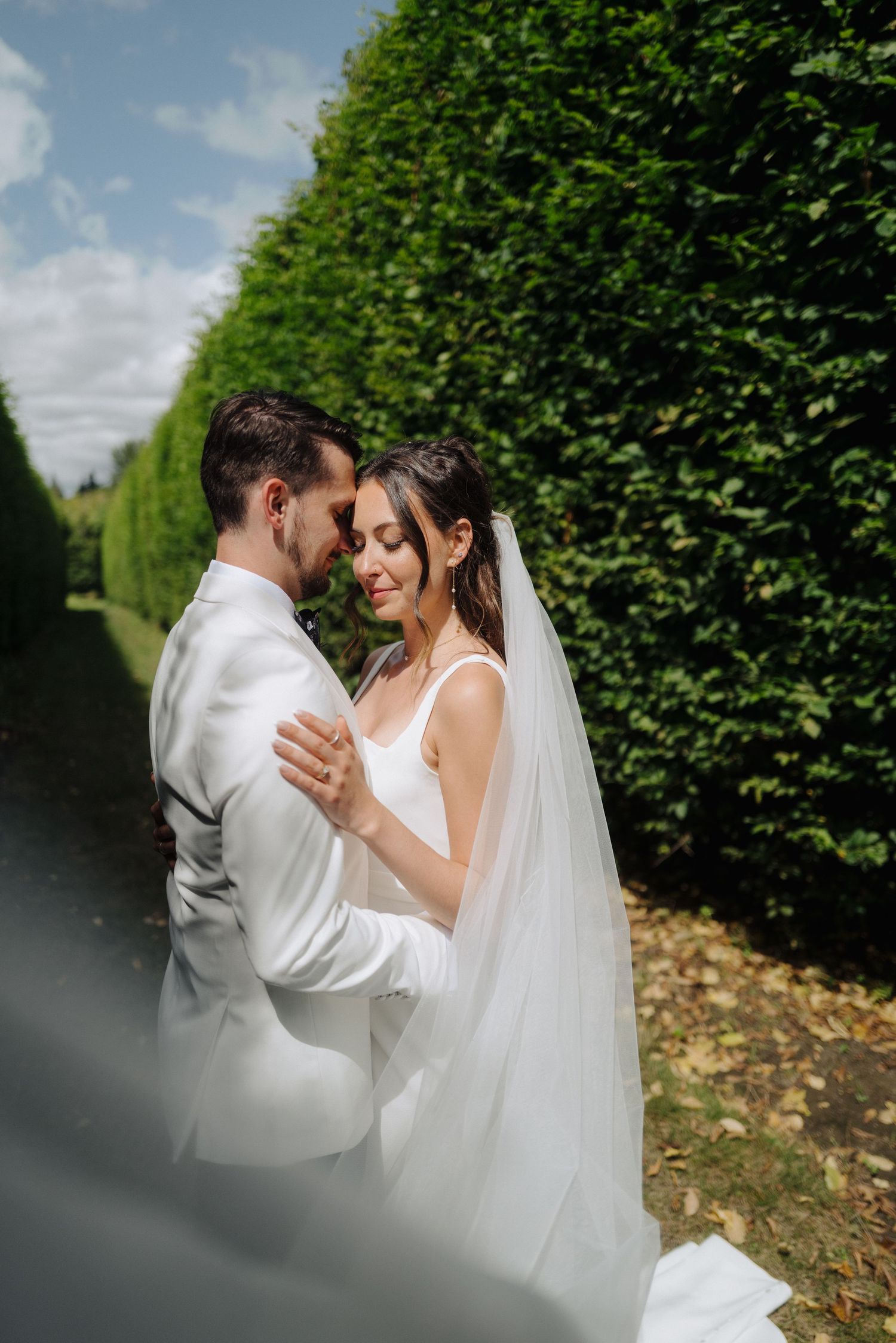 Romantic garden wedding scene with tall green hedges creating an intimate backdrop.