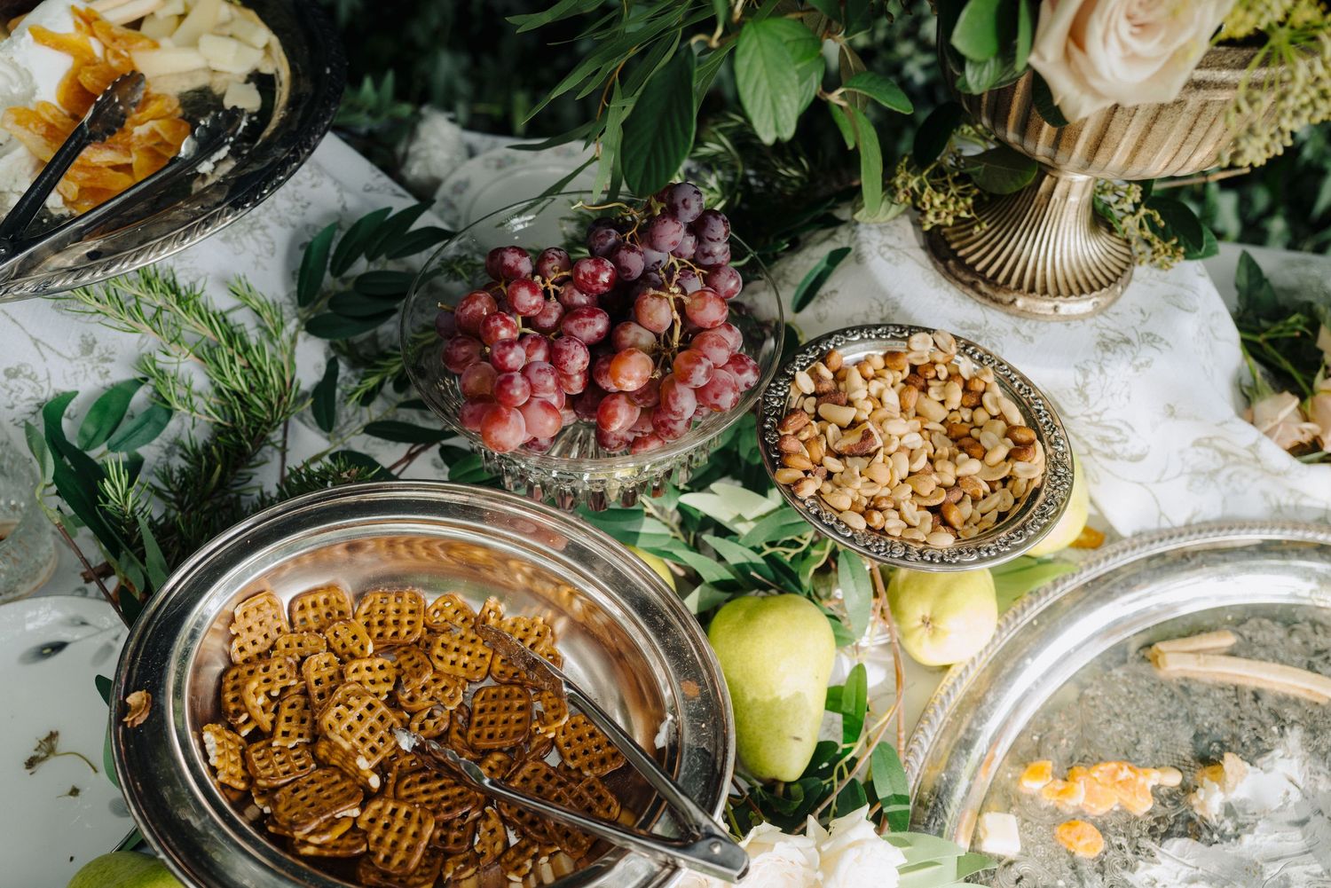 Elegant wedding reception table spread with gourmet appetizers and decorative arrangements.