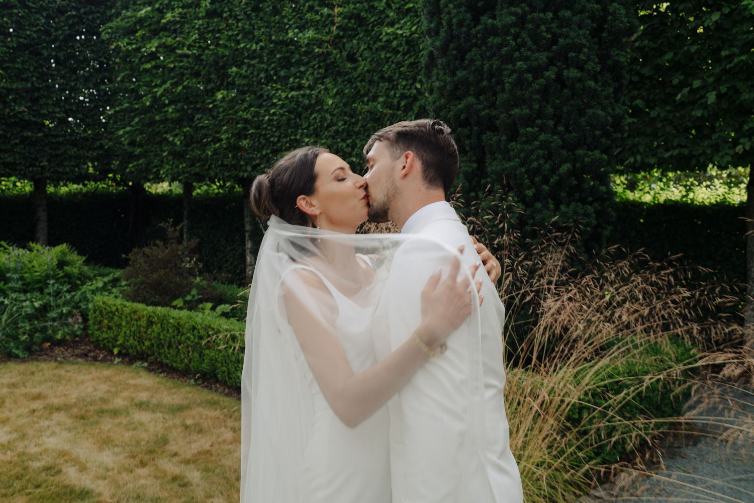 Romantic wedding moment captured in a lush garden setting with natural lighting.
