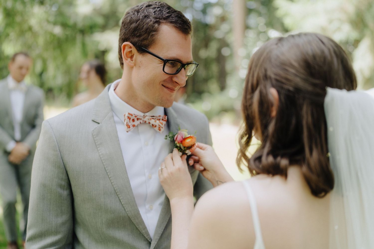 A couple shares a tender moment during their outdoor wedding ceremony in a lush garden setting.