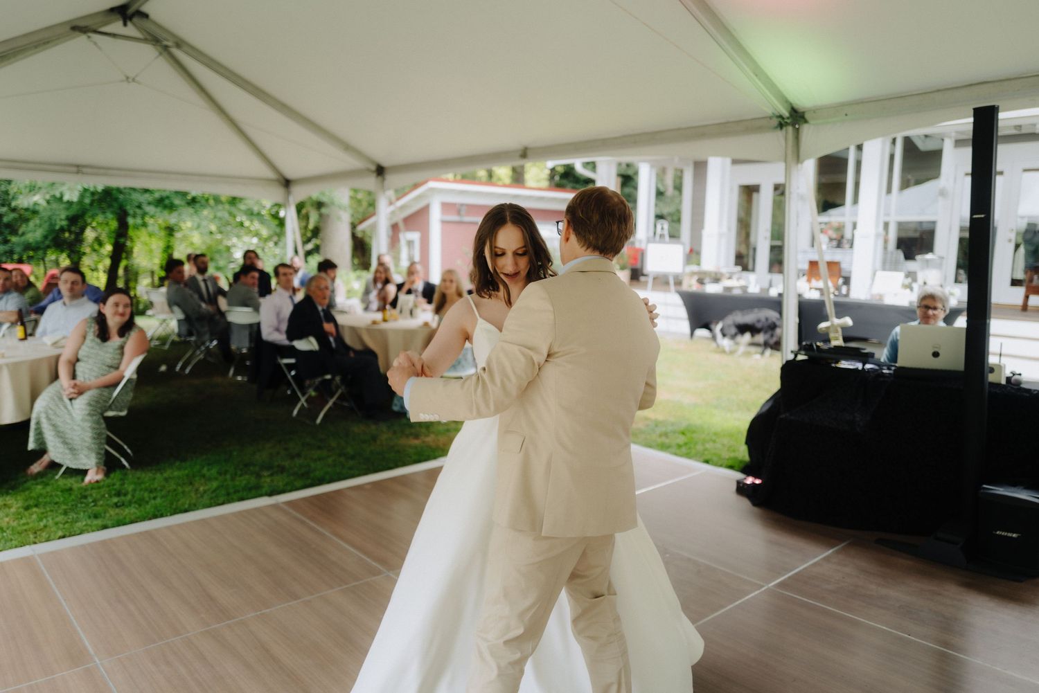 Outdoor wedding venue with white tent setup and tables arranged for an elegant celebration.