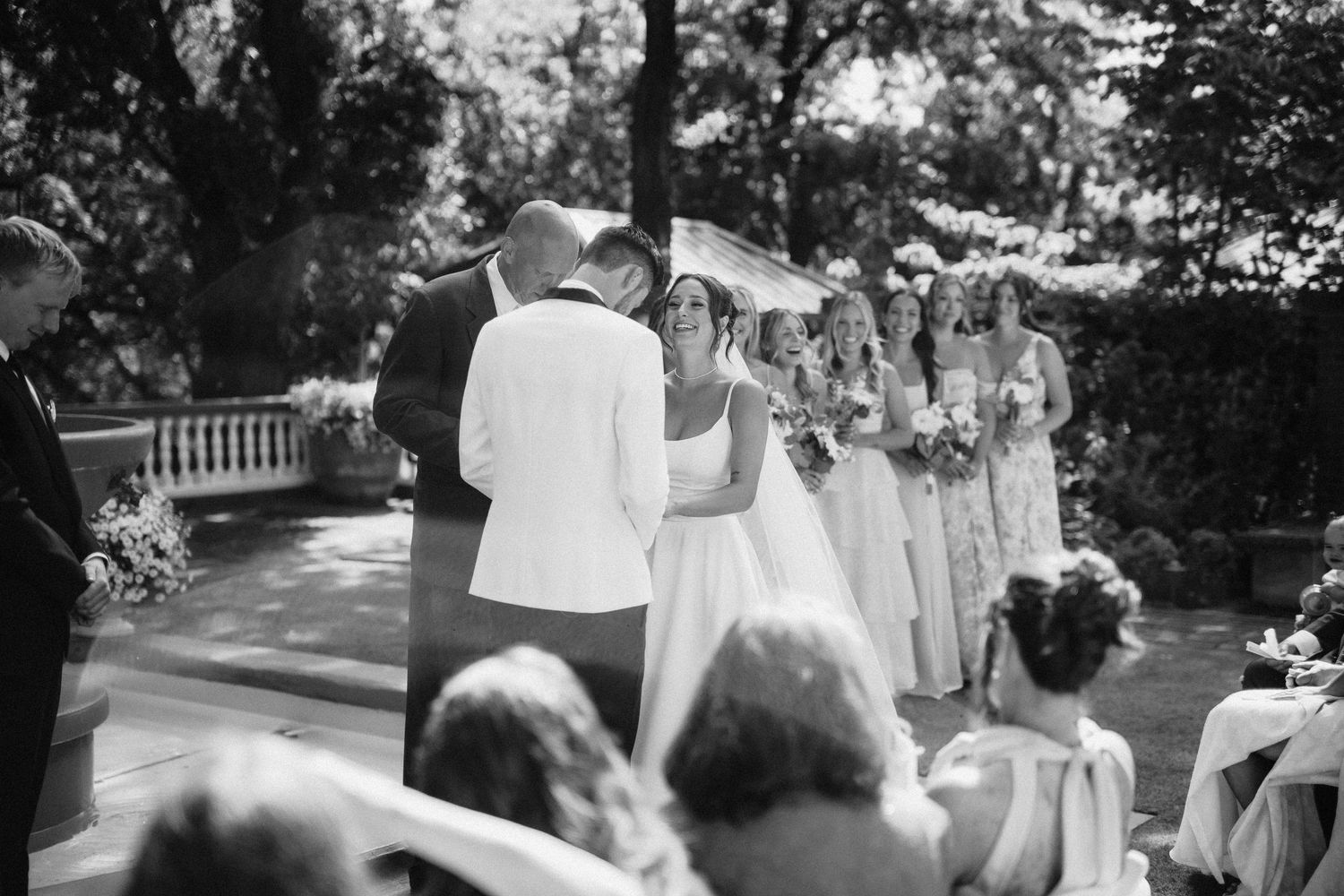 A series of black and white wedding photographs showing a celebration in an outdoor garden setting.