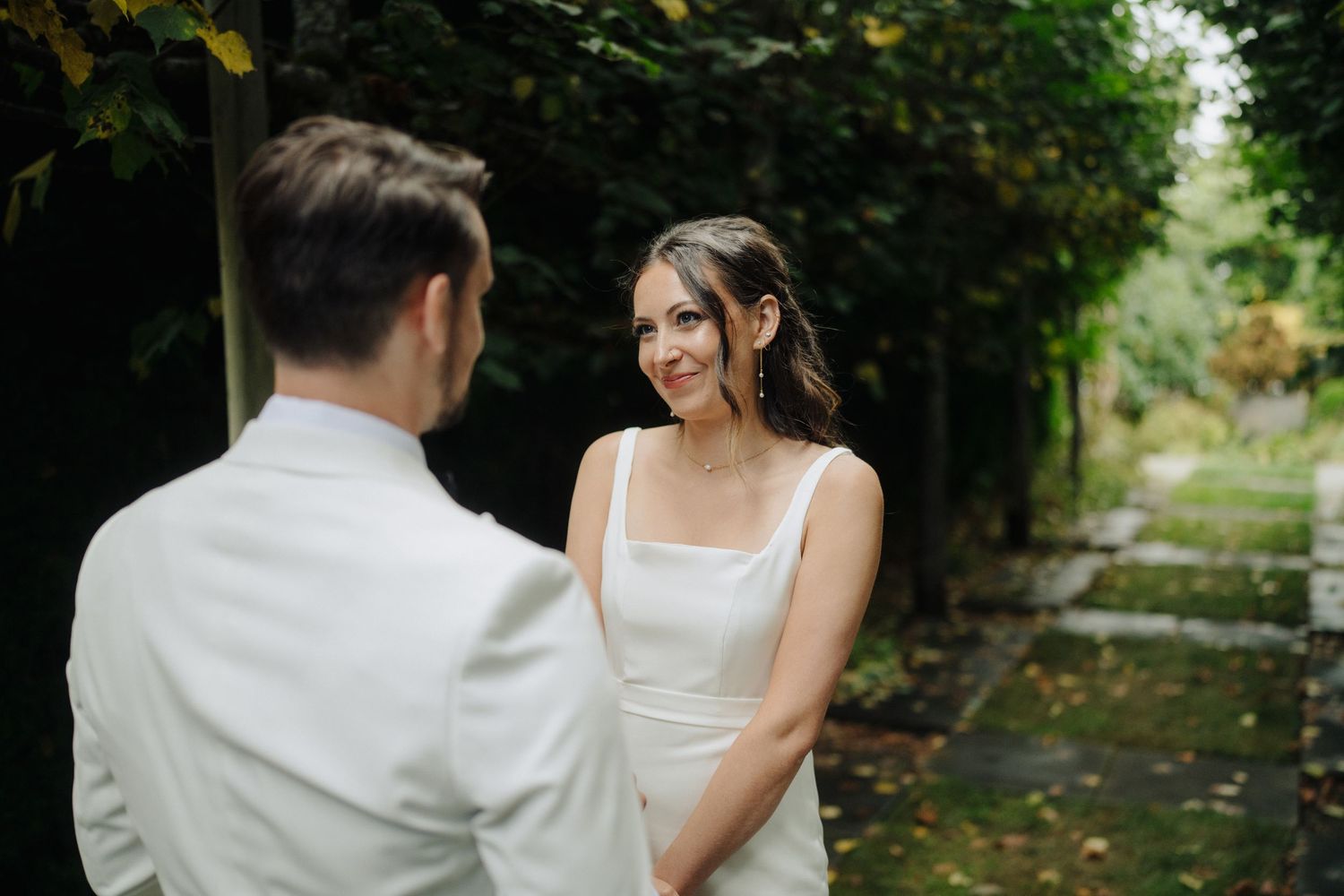 A romantic outdoor wedding moment with the couple sharing a tender dance in a garden setting.