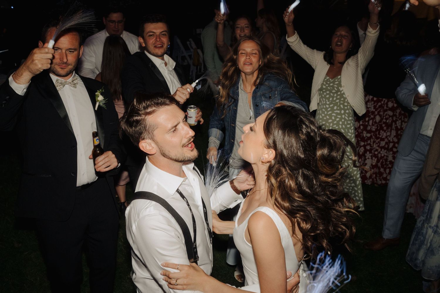 Wedding guests dance and celebrate during evening reception.