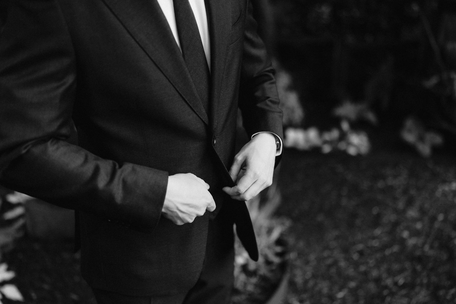 Groomsmen in black suits stand together before the wedding ceremony.