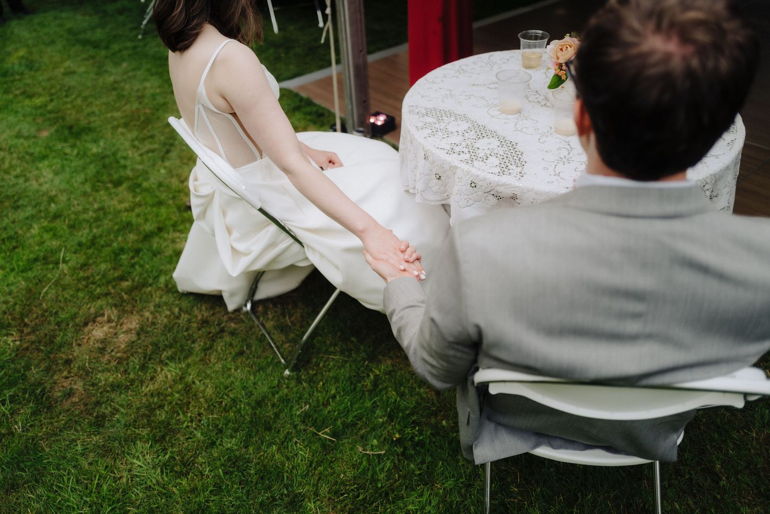 Intimate moment at outdoor wedding reception with white lace tablecloth.