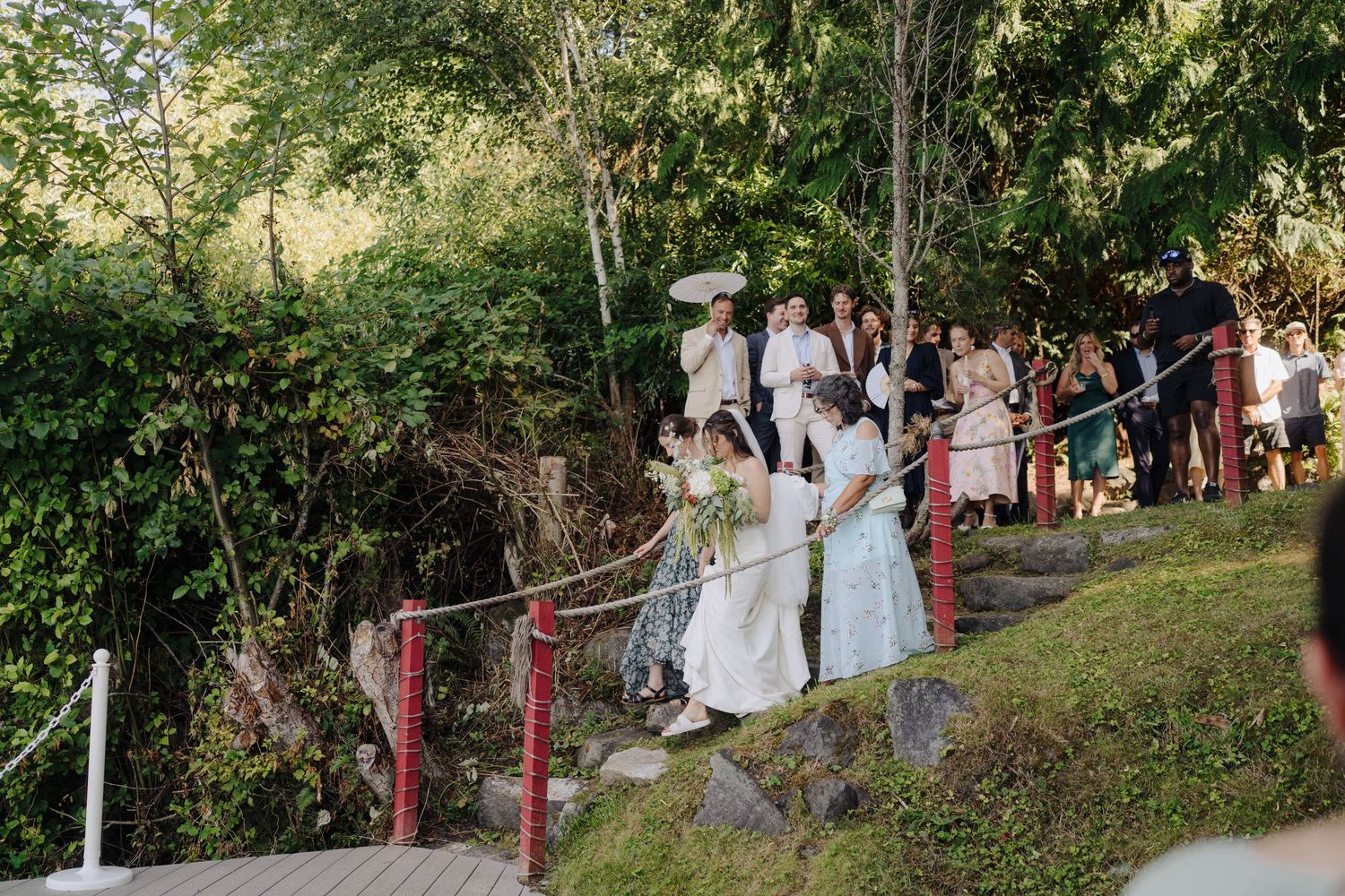Outdoor wedding ceremony with guests seated on wooden benches overlooking the ocean.