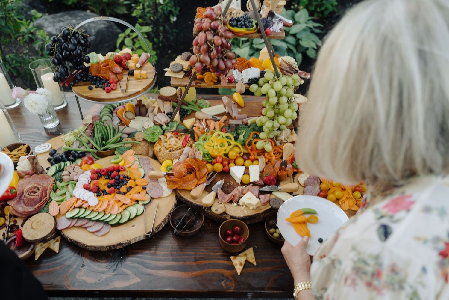 Elegant wedding reception grazing table with abundant appetizers and floral decorations.