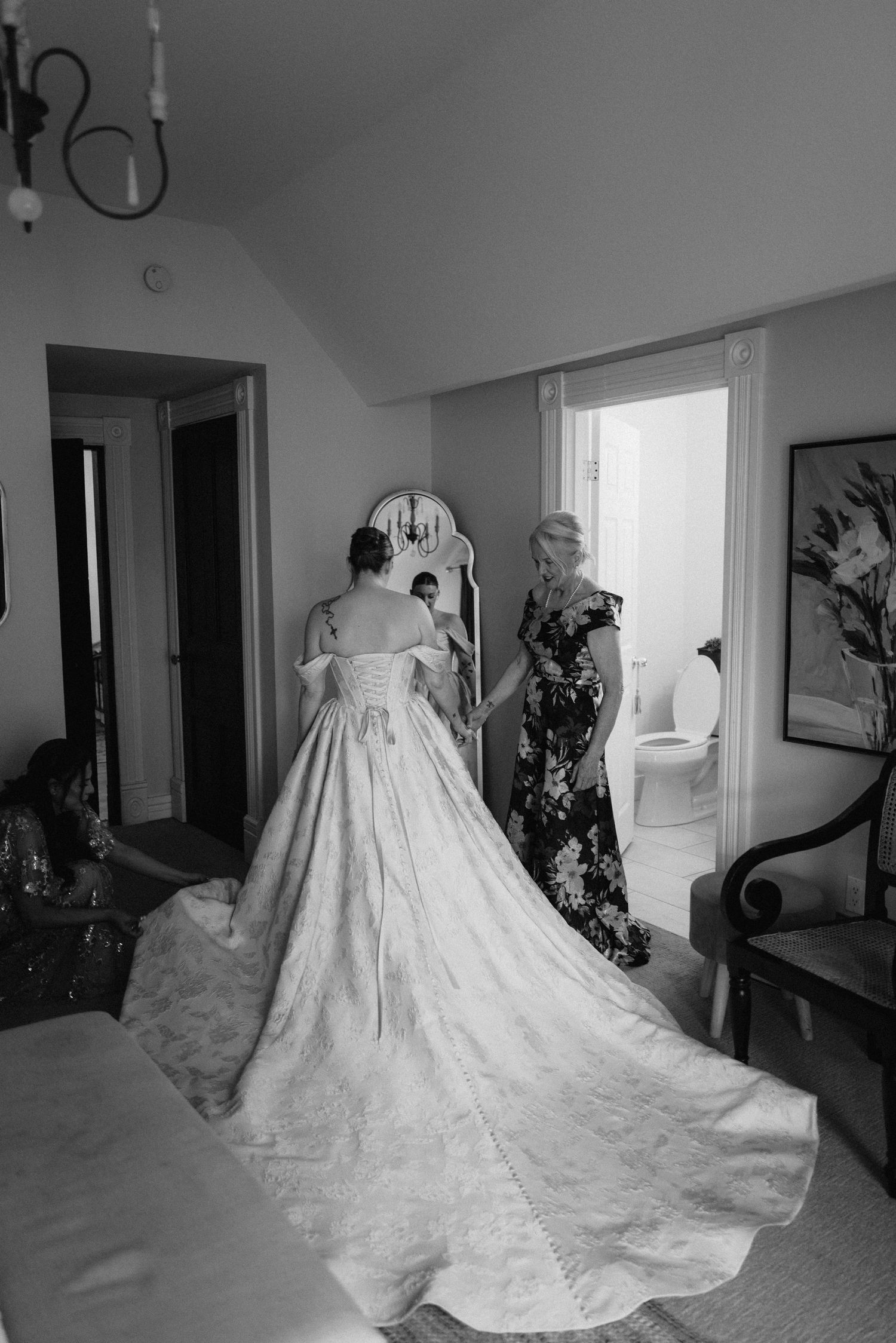 A stunning white wedding dress with a long cathedral train displayed in a bridal preparation room.
