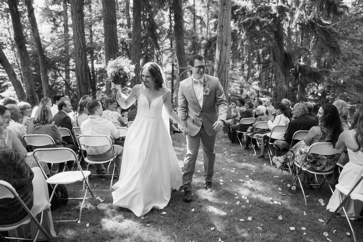 Candid moments from forest wedding ceremony with guests seated among tall trees.