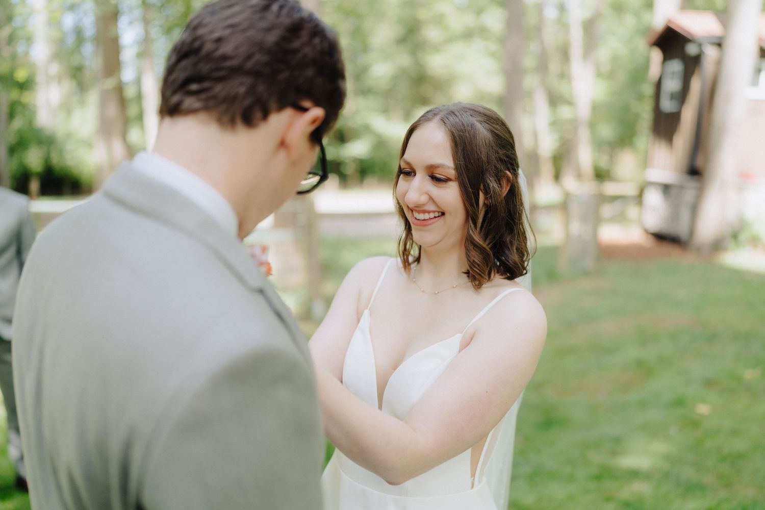 A tender first look moment between a bride and groom in an outdoor garden setting.
