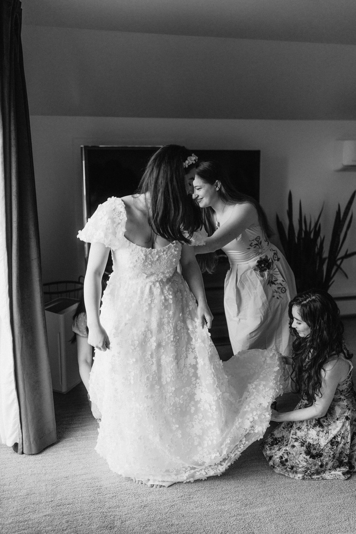 A white lace wedding dress laid out on the floor in a series of artistic black and white photographs.