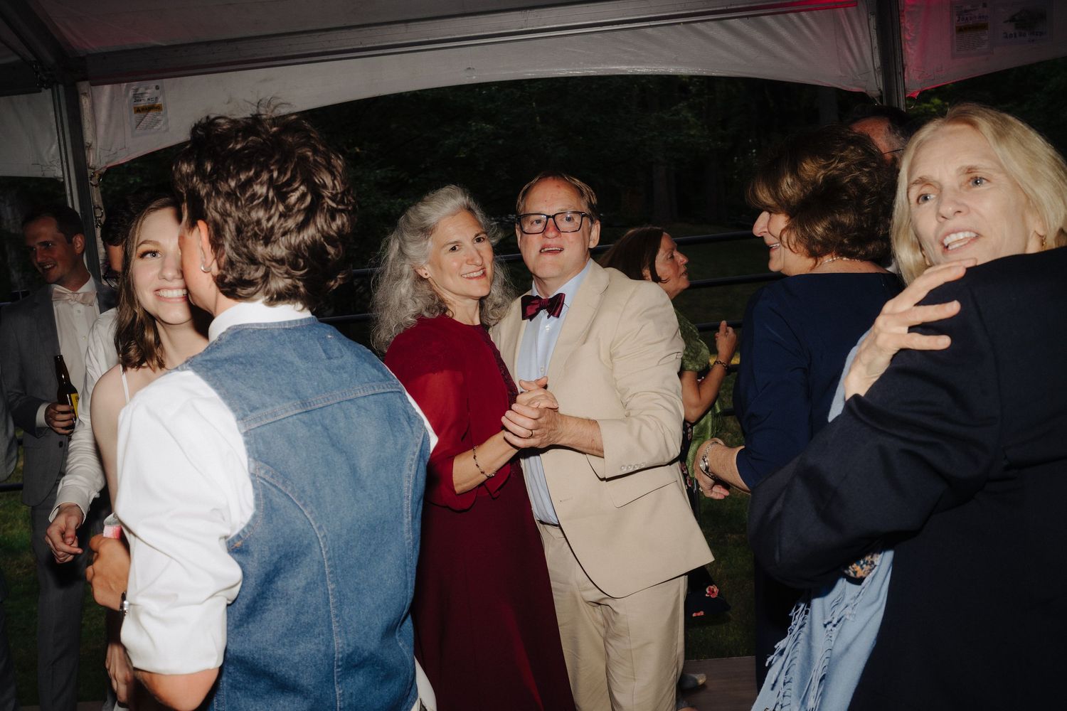 Couples dancing together during an evening wedding reception celebration.