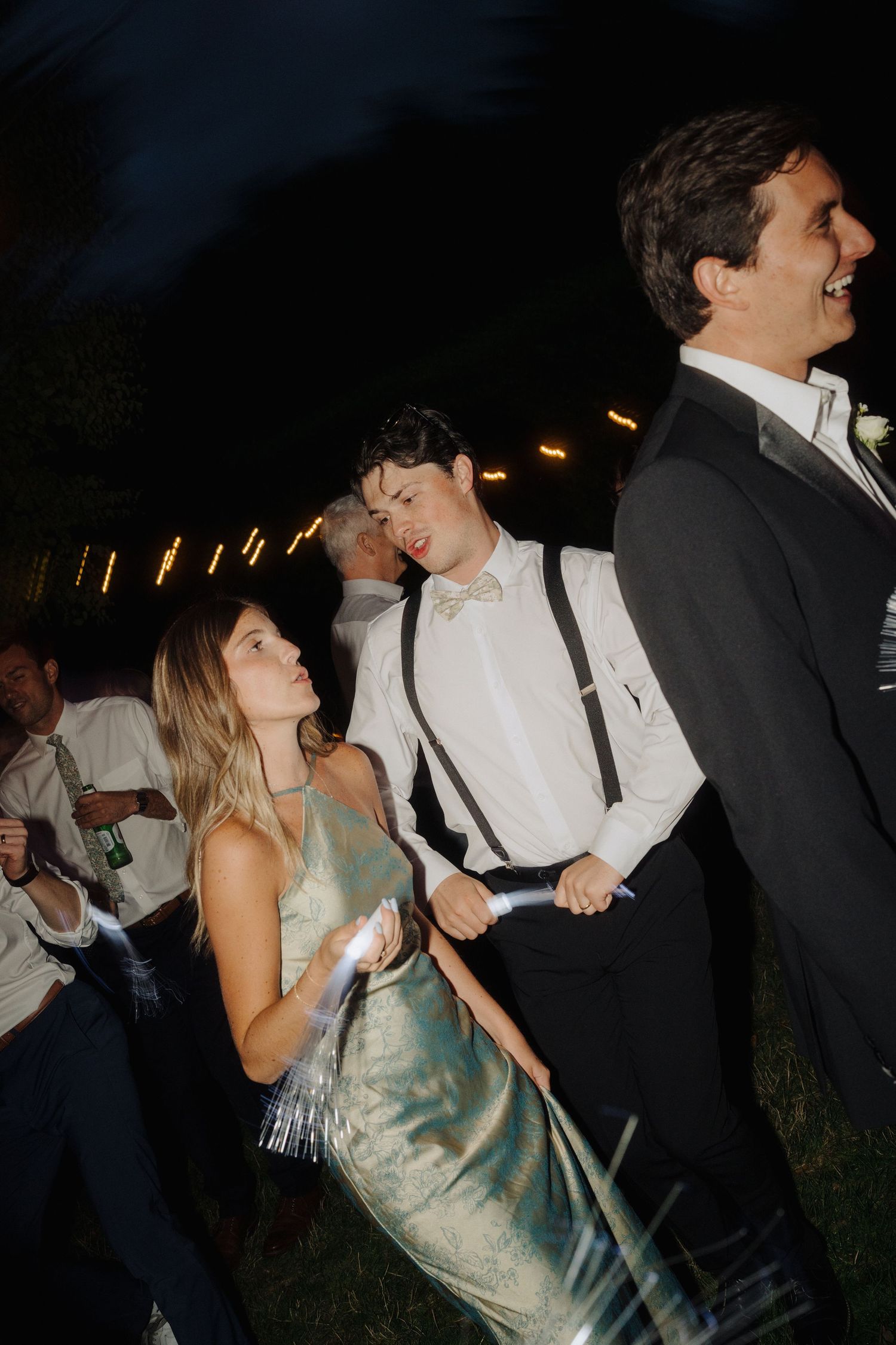Couple dancing together at a wedding reception with the woman wearing a green dress.