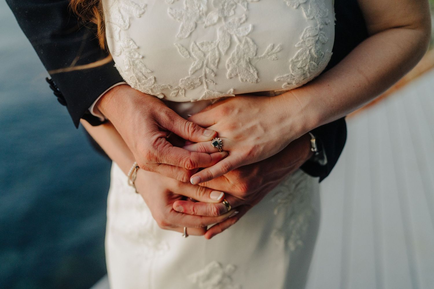 Close-up detail of delicate lace and beading on a white wedding dress.