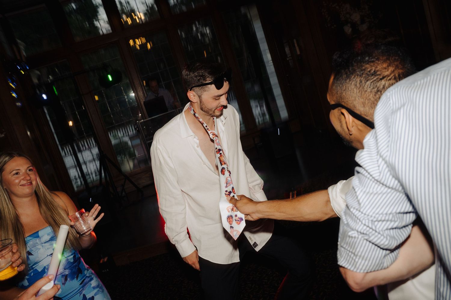 Guests dancing and celebrating at a lively nighttime wedding reception.