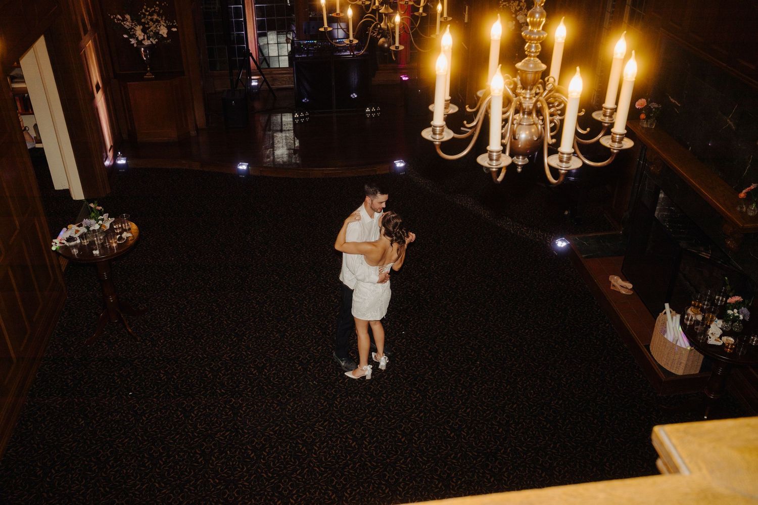 Candlelit wedding reception venue with elegant chandeliers creating romantic ambiance.
