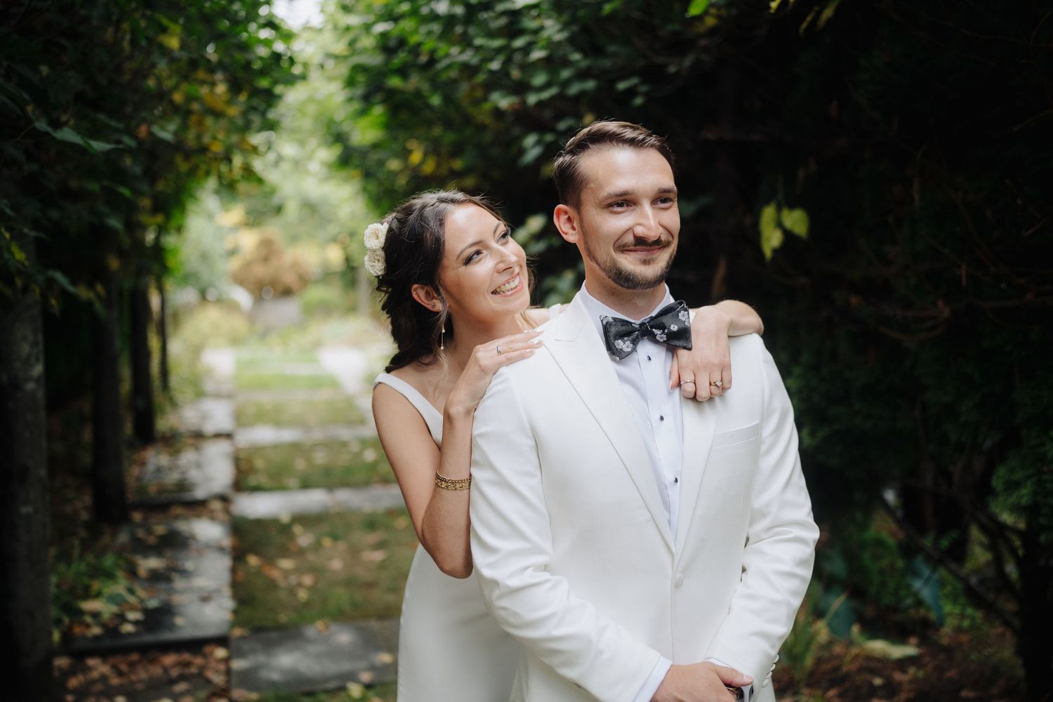 A romantic outdoor wedding celebration with guests gathered in a garden setting.