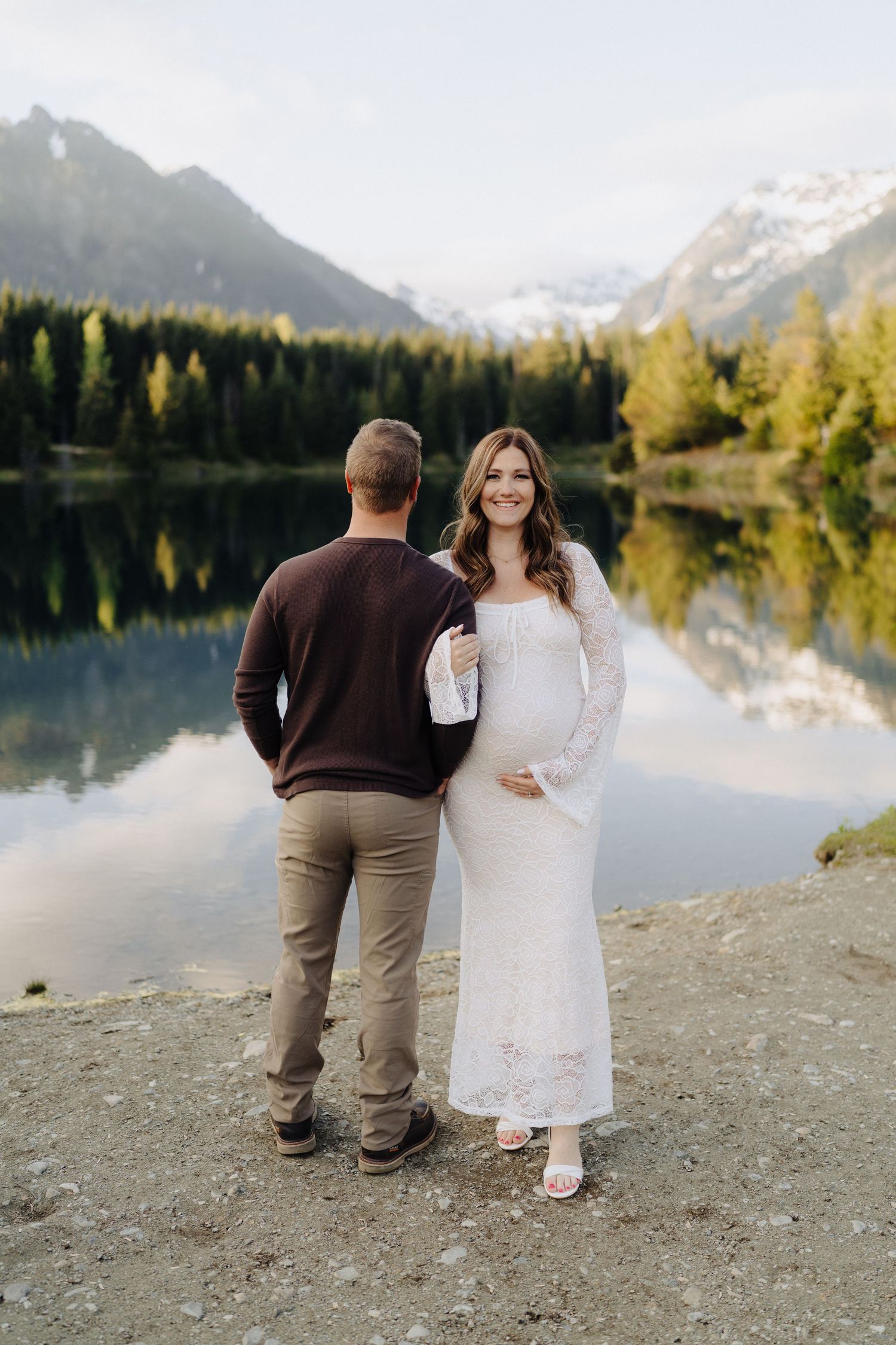 A romantic lakeside photoshoot with mountain views and fall foliage reflecting in the calm waters.
