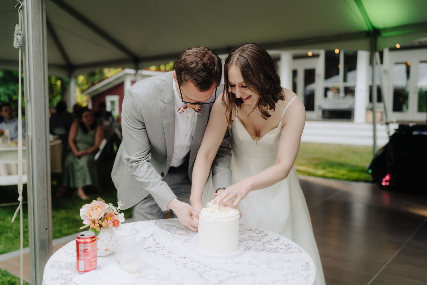 A couple signs their marriage certificate at a wedding ceremony while others look on.