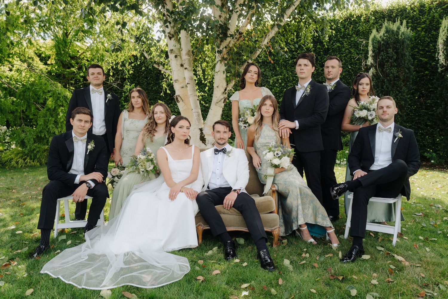 Casual wedding party portraits taken in a garden setting with natural lighting.