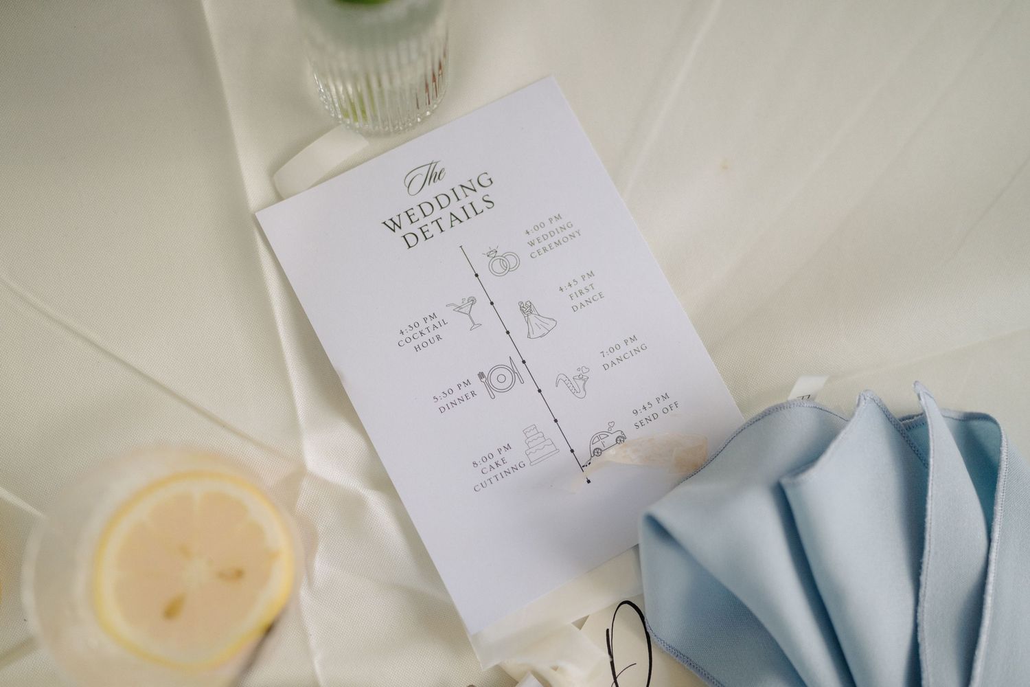 Wedding reception seating chart diagram with blue napkin and candle on white surface.