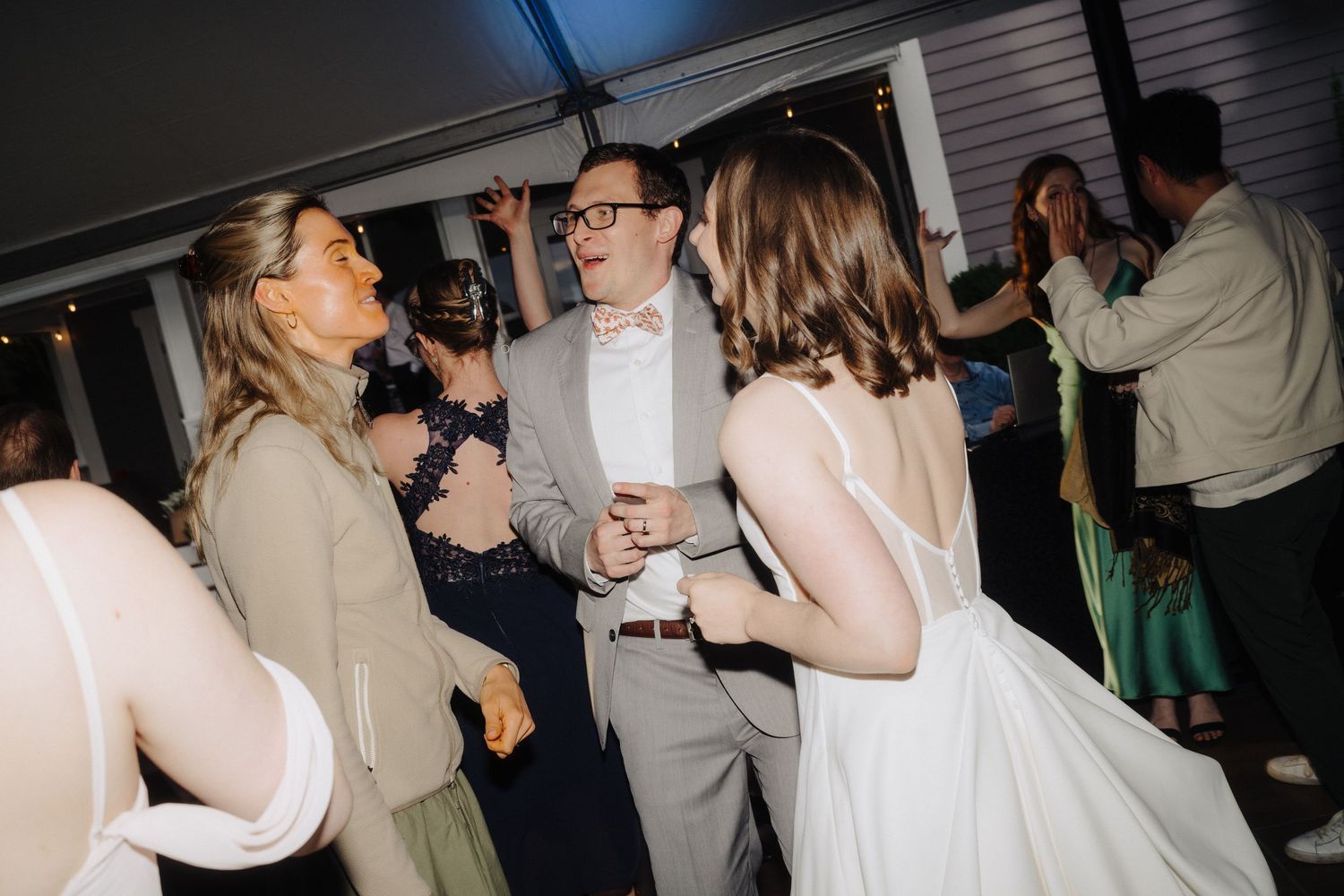 Wedding reception guests dancing and socializing at an indoor venue.
