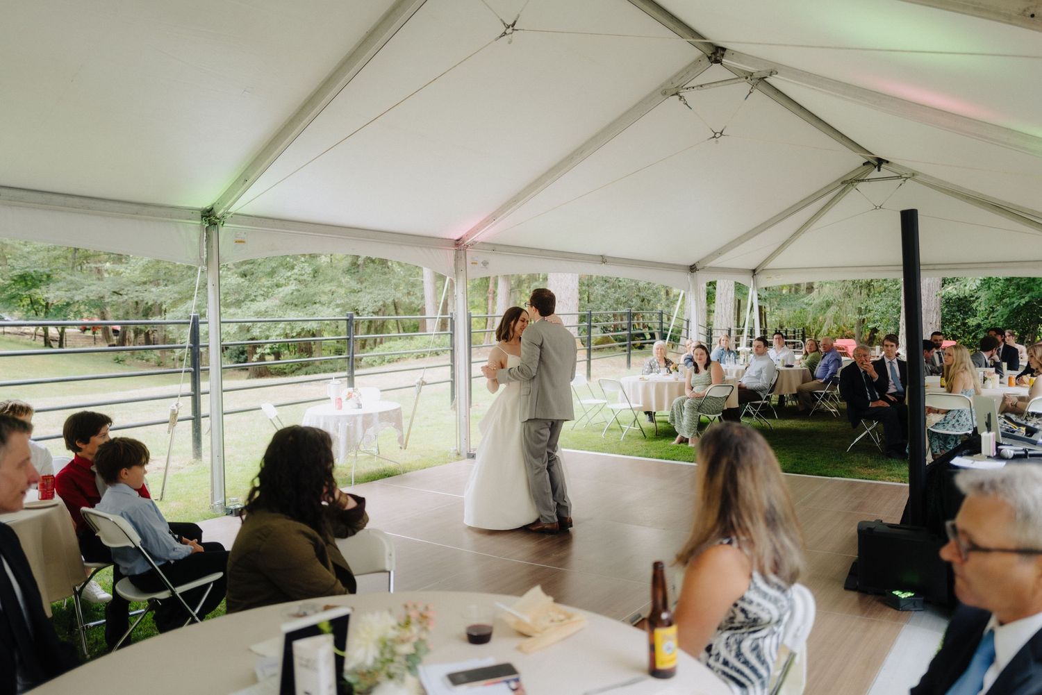 Panoramic view of white reception tent with tables set for wedding celebration.