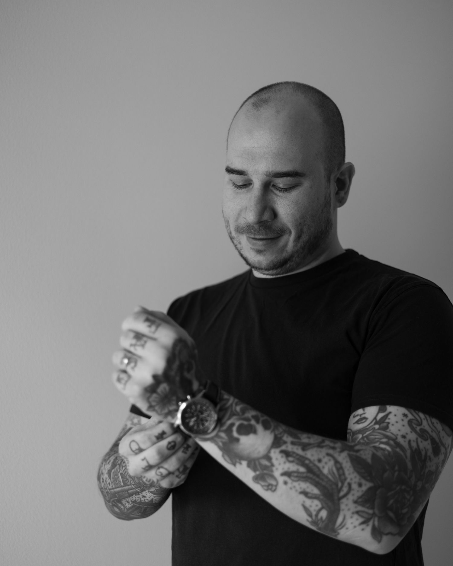 Tatuoitu mies asettelee kelloa kädessään. Mieskuvaus järvenpäässä.