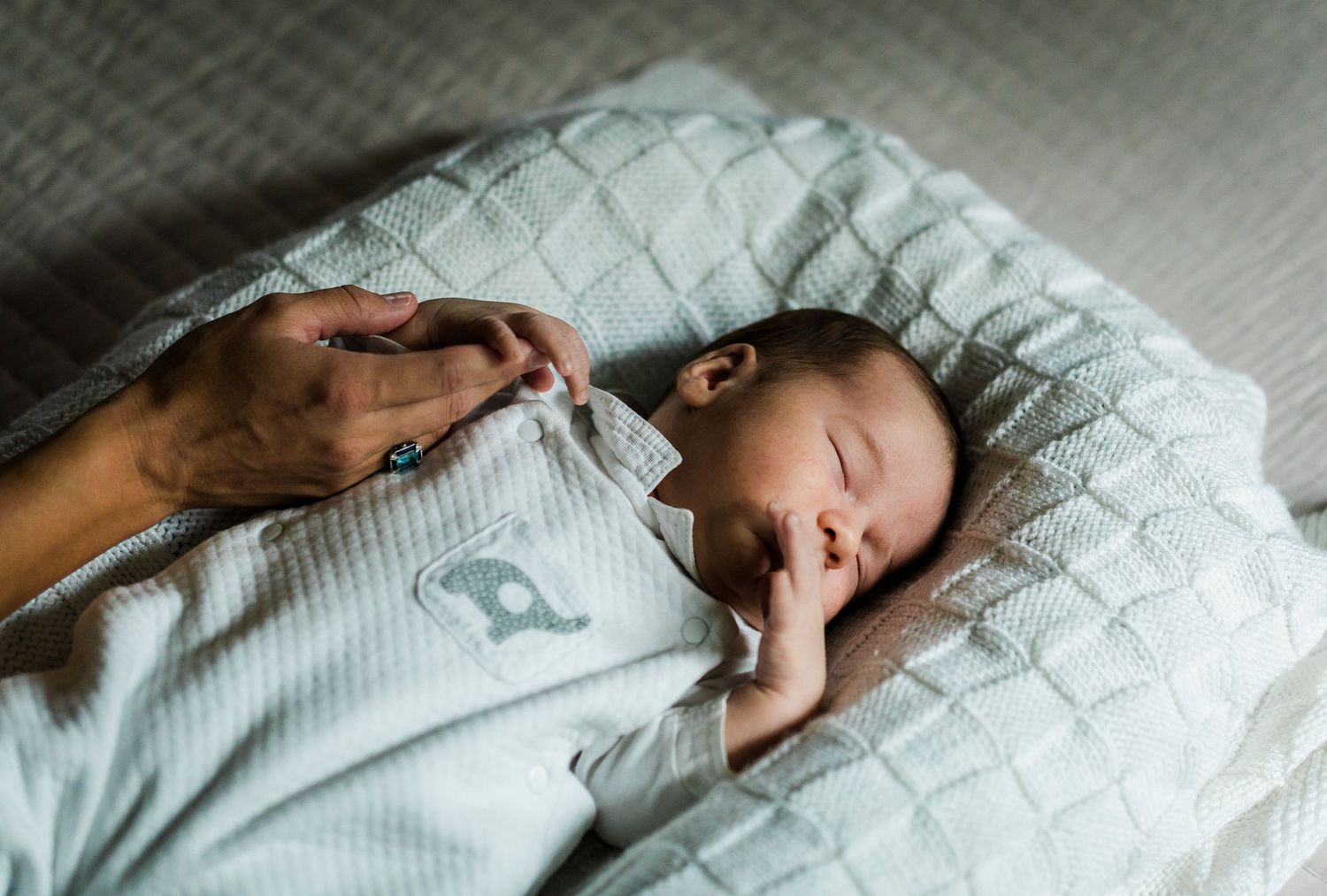 Close-up shots of peaceful sleeping moments on textured white bedding.