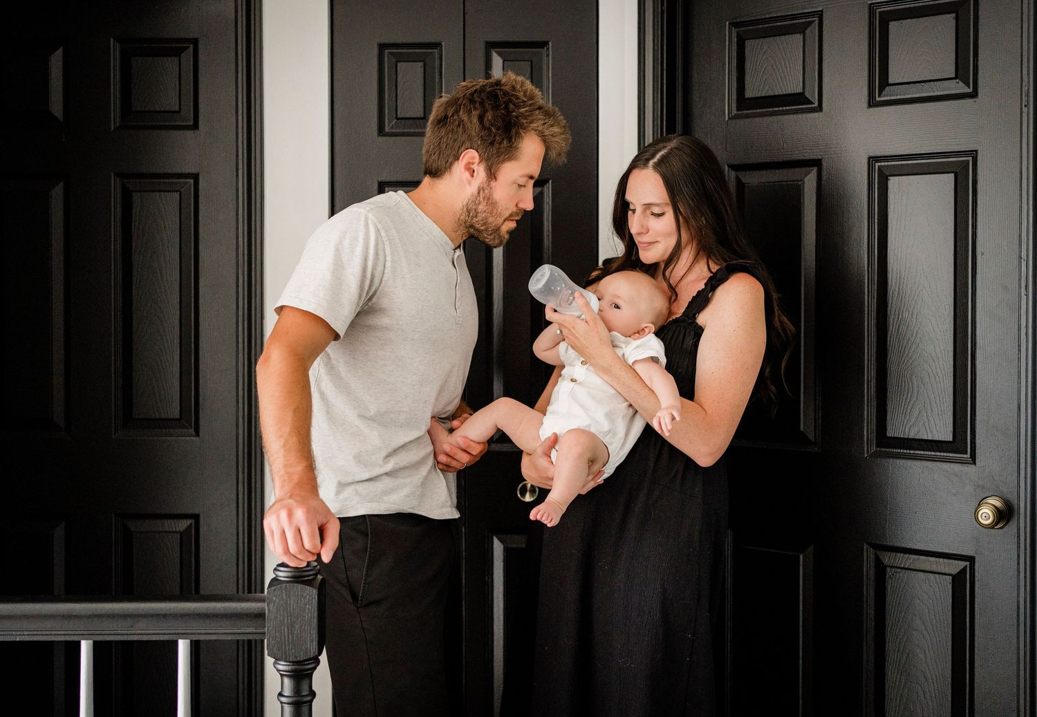 Series of candid family moments against black doors in a modern hallway.