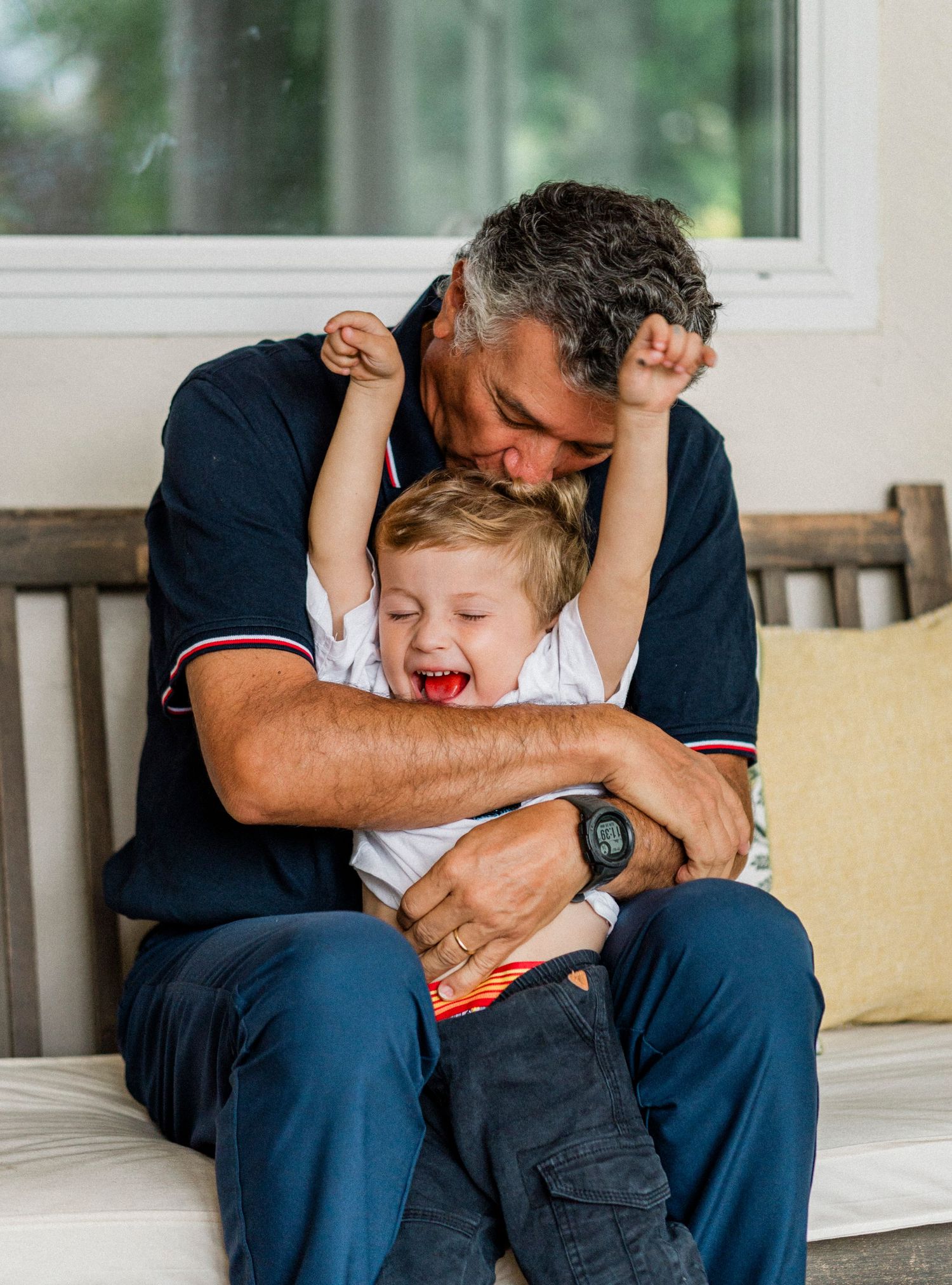 A series of candid photos showing tender moments between a parent and child playing together on a porch bench.
