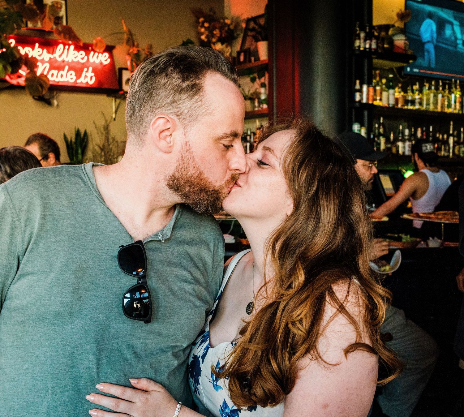 Romantic evening photos of couple sharing intimate moments in a dimly lit bar setting.