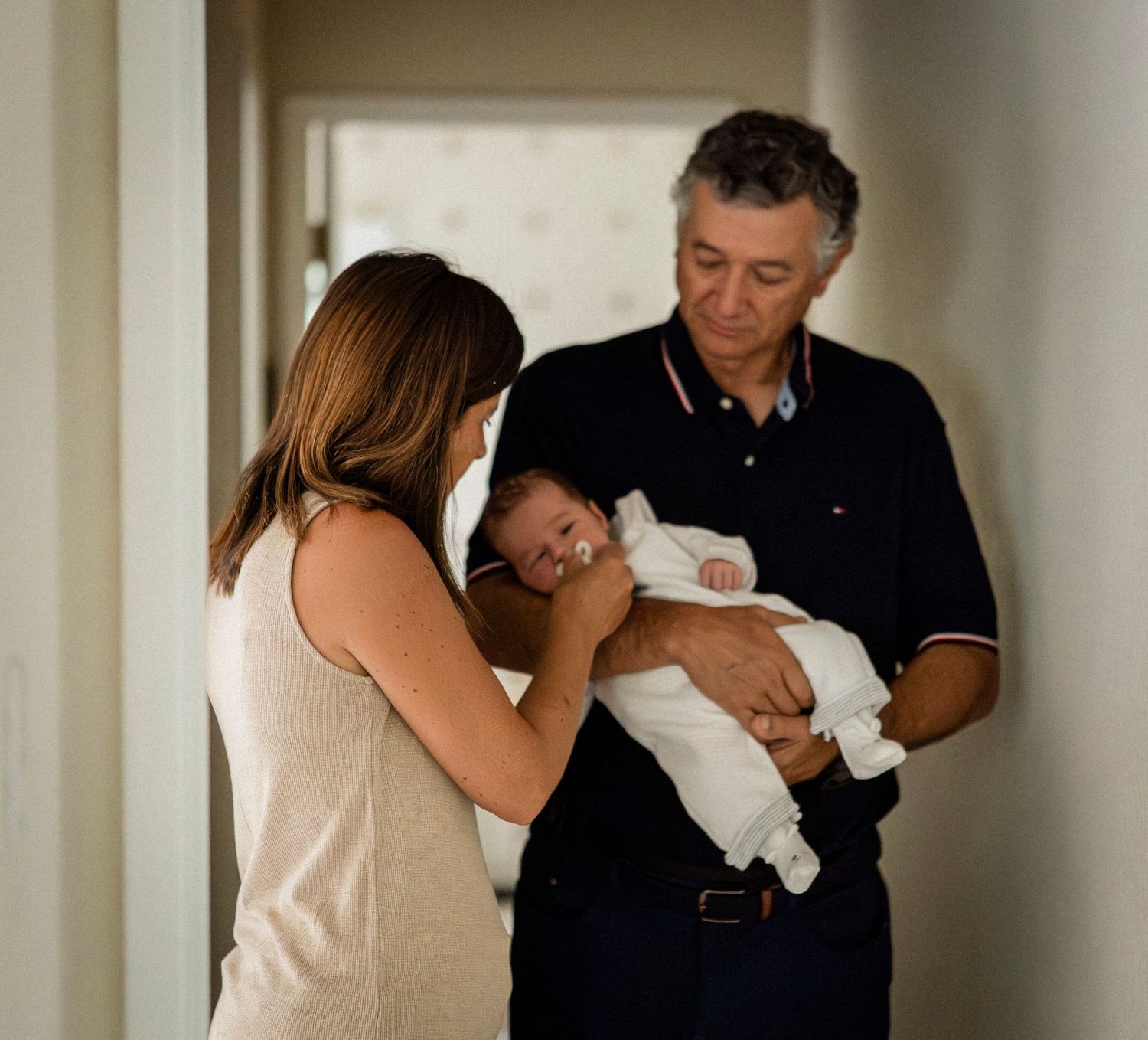 A series of intimate moments showing adults cradling and bonding with a newborn indoors.