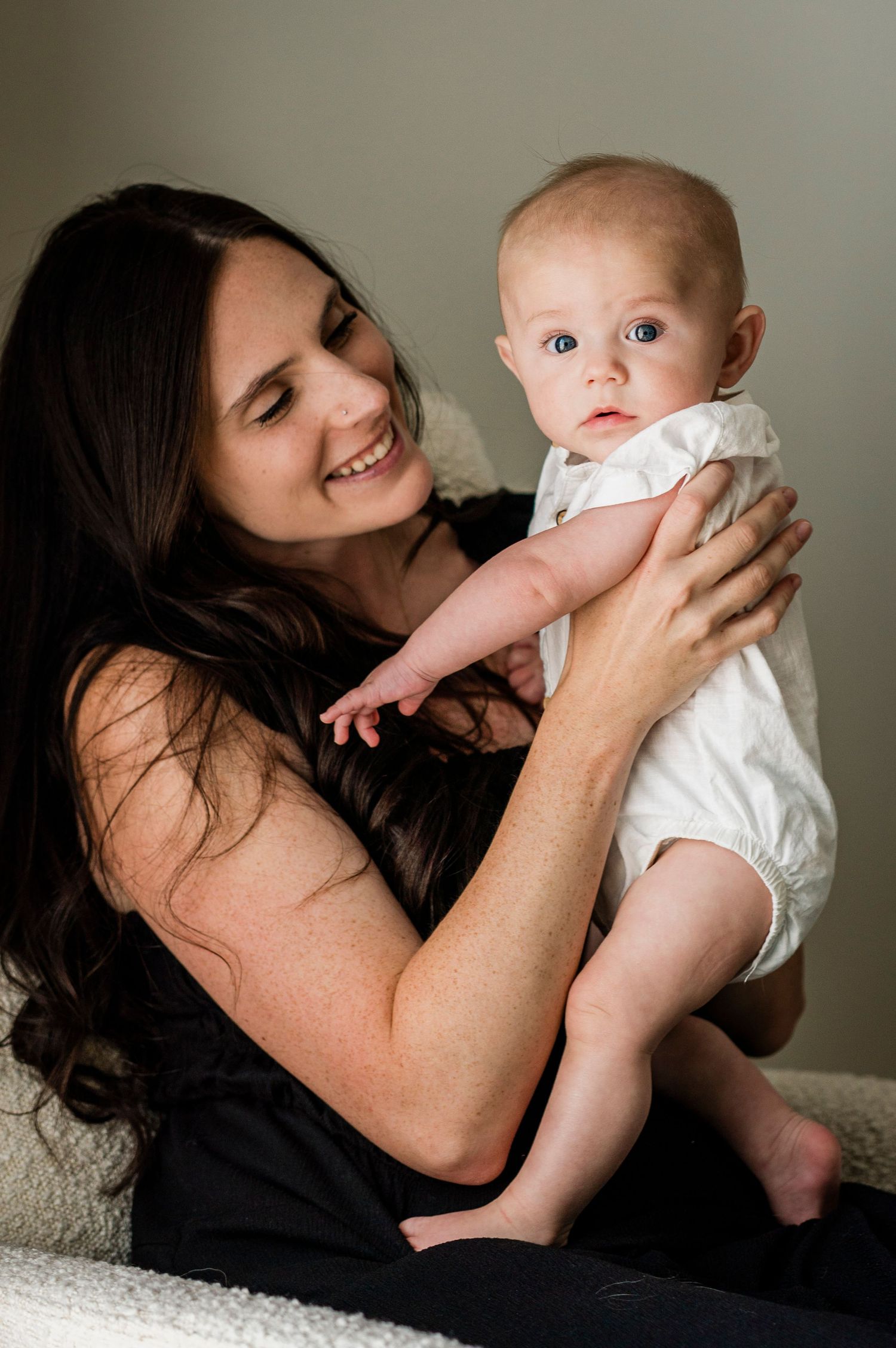 Intimate portrait series of tender moments between mother and baby on white backdrop.