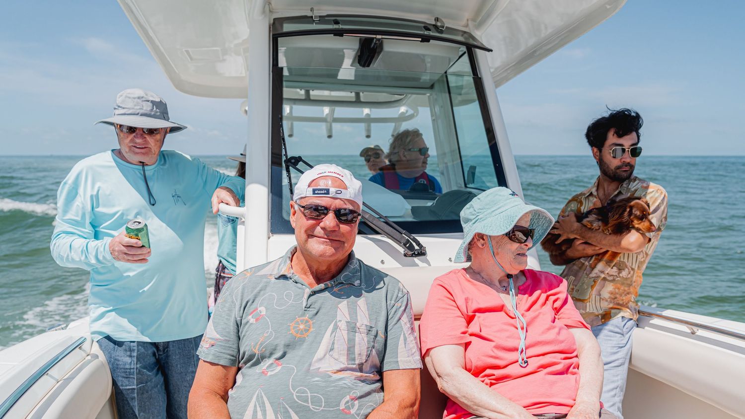 Group enjoying a sunny day on a boat out on the ocean waters.