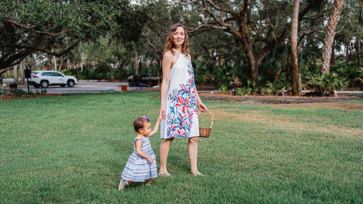 A peaceful moment shared between two figures on a grassy lawn surrounded by trees.