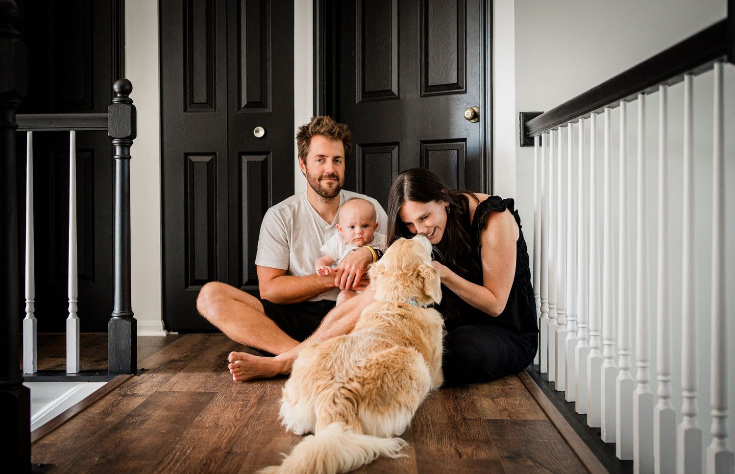 Golden retriever and family sharing playful moments on hardwood floors.