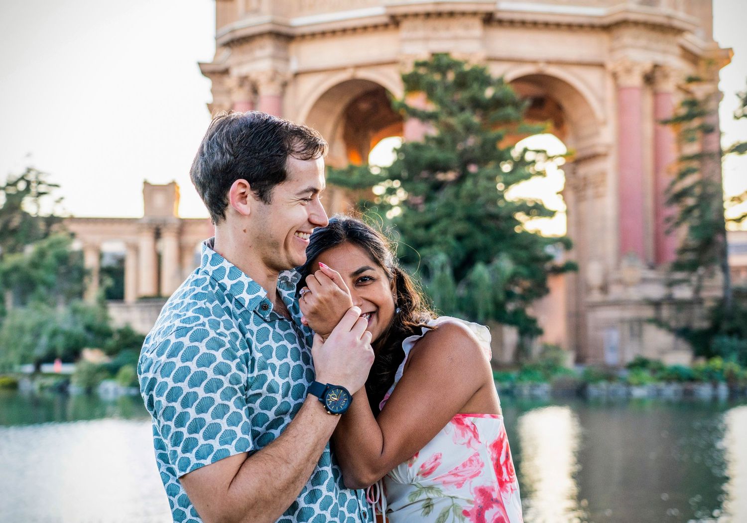 A couple sharing a joyful moment in front of the Palace of Fine Arts in San Francisco.