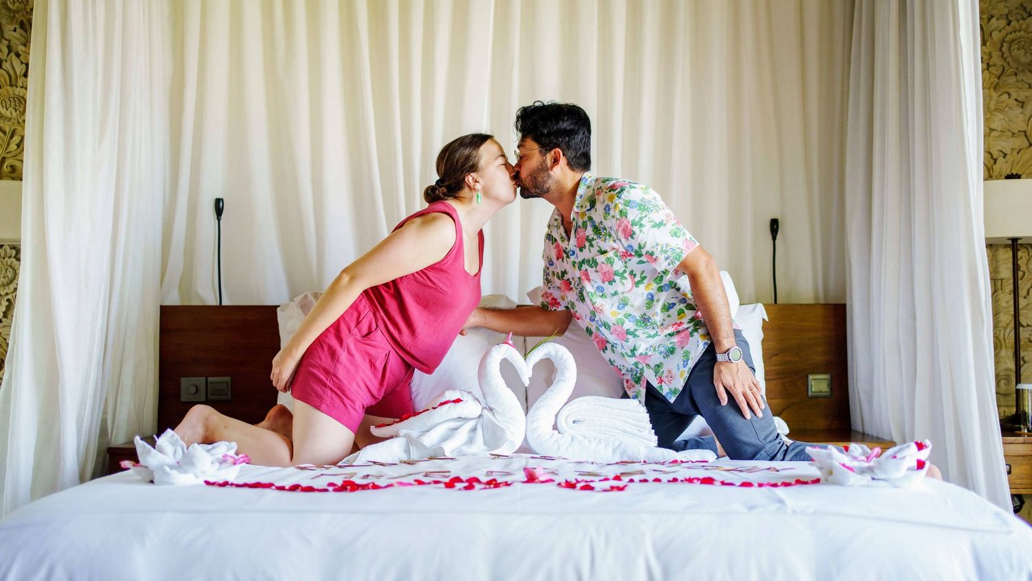 Series of intimate moments of honeymoon couple captured on white bed with gold-toned wall decor.