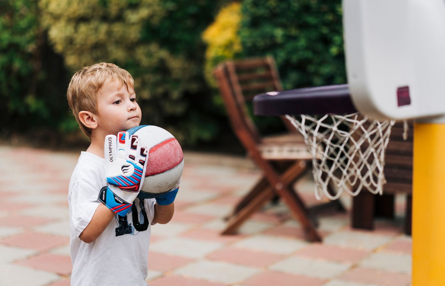 Young basketball player practicing dribbling skills on an outdoor court with multiple basketballs.