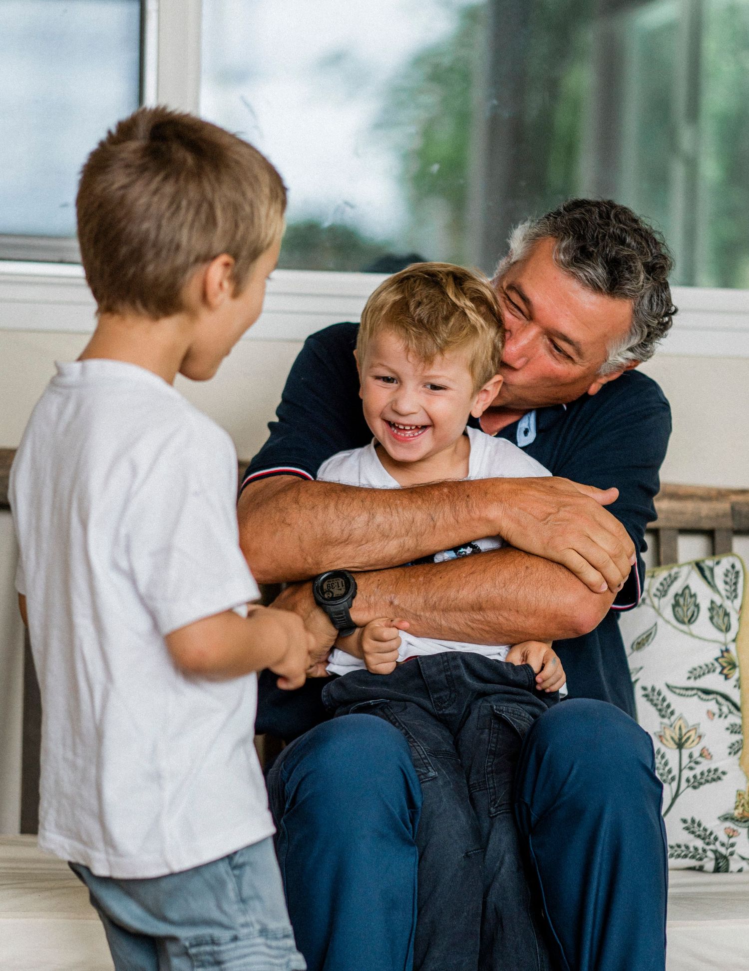 A series of candid family moments showing playful interaction and laughter between parent and child on a couch.