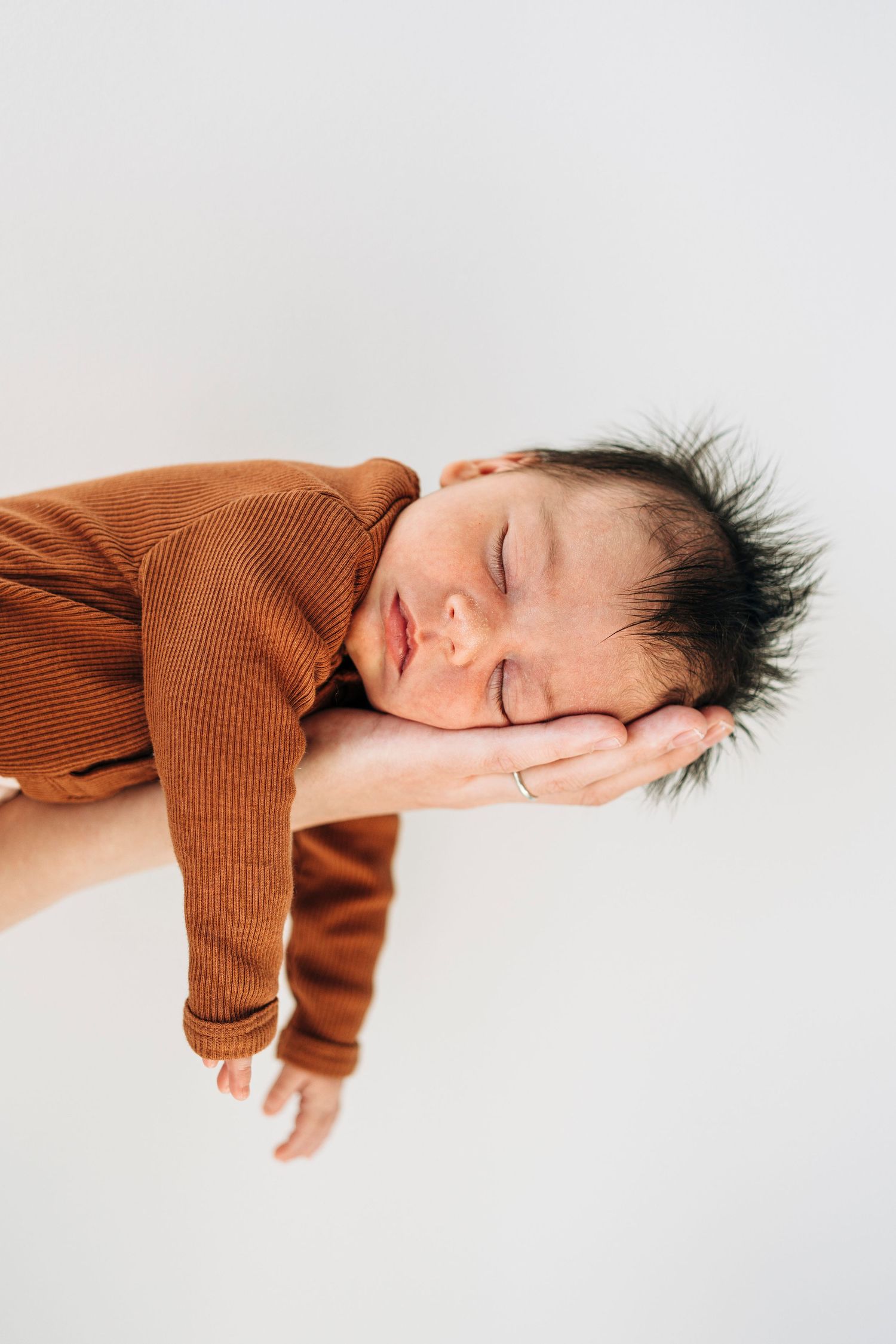 A sequence of artistic portraits showing a person in rust-colored sweater resting on white background.