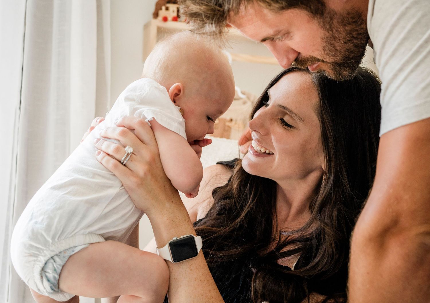 Intimate family moment captured in a bright, minimalist setting.