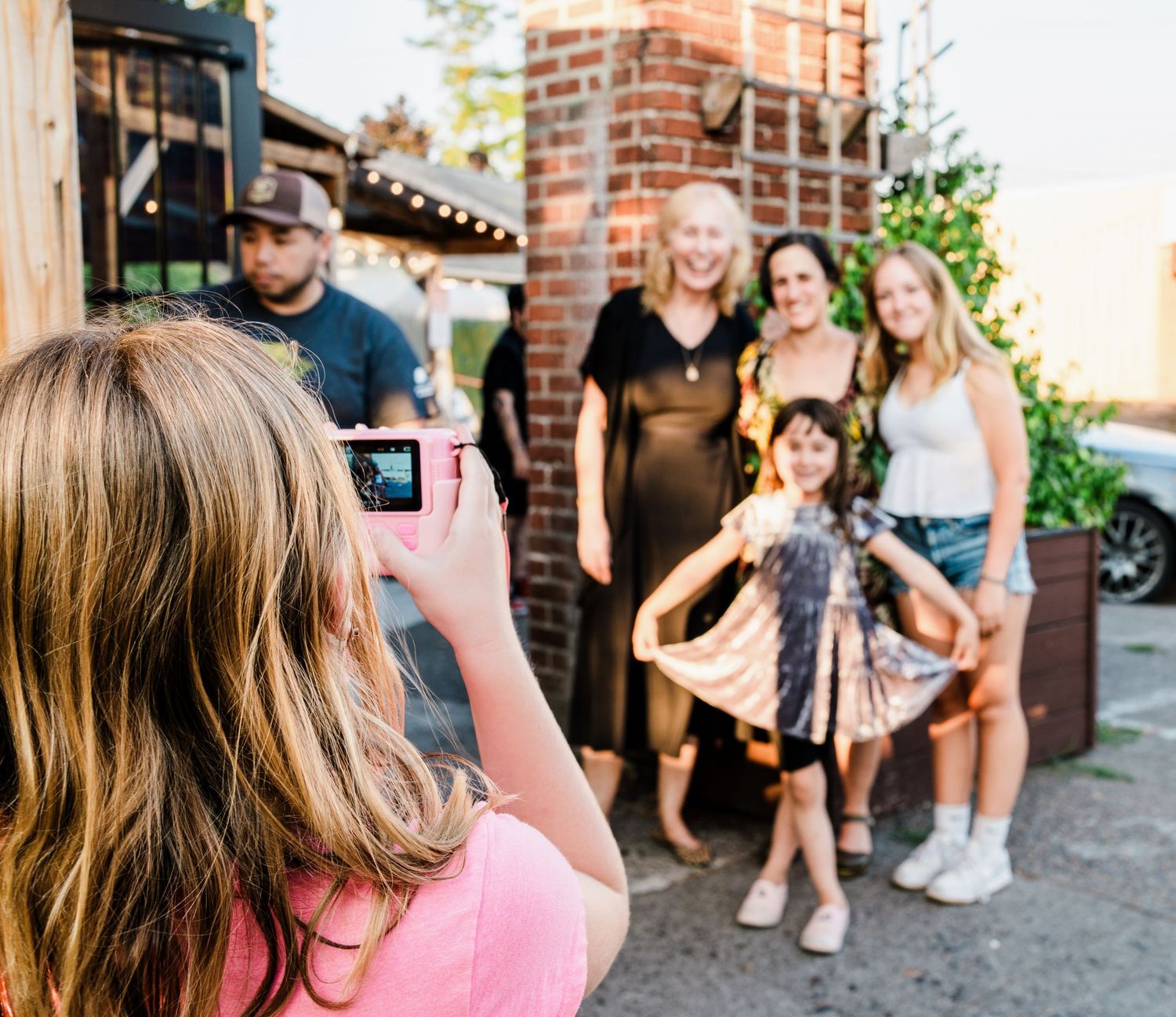 People gathered outside a brick building for casual social event.