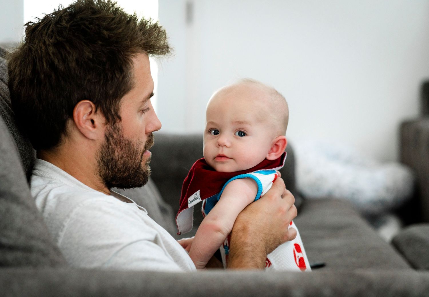 Tender sequence of dad and infant son bonding moments showing playful interactions and cuddles.